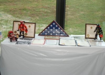 A table displaying a flag, a plaque, and a picture of a fireman, representing honor and appreciation.