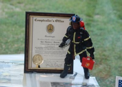 A toy firefighter figurine standing proudly next to a certificate of achievement.