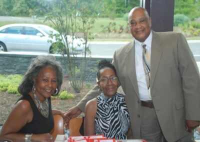 Three people sitting at a table with a red box.