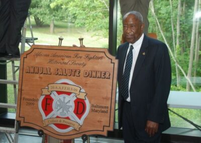 Man in suit holding plaque reading 'National Fire Service Center