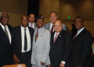 A group of businessmen in suits and ties standing together at a corporate event.